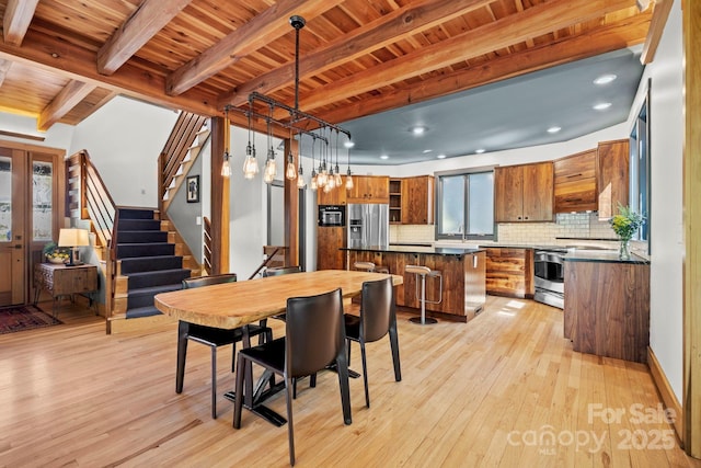 dining room with light wood finished floors, wood ceiling, and beamed ceiling