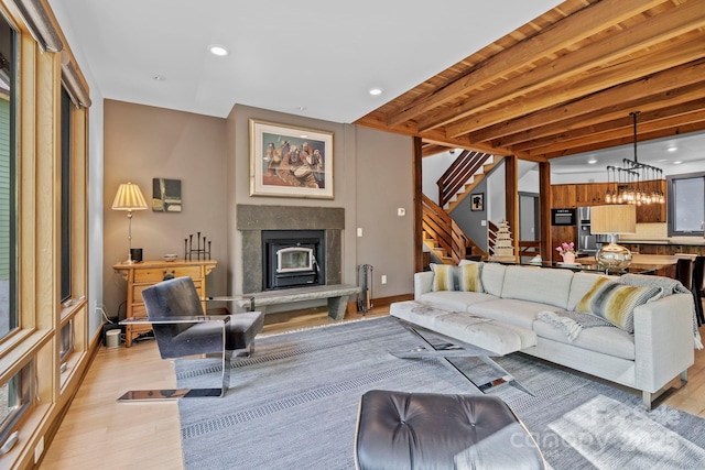 living area with beam ceiling, recessed lighting, baseboards, light wood-type flooring, and stairway