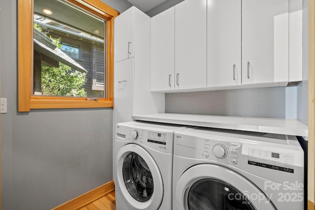 clothes washing area featuring cabinet space and washing machine and dryer