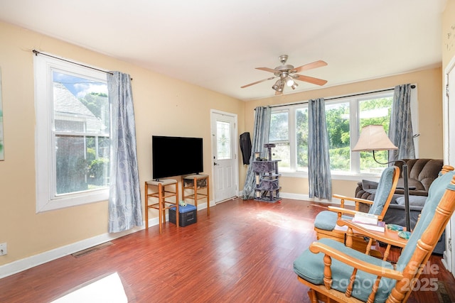 sitting room featuring wood finished floors, baseboards, and a ceiling fan
