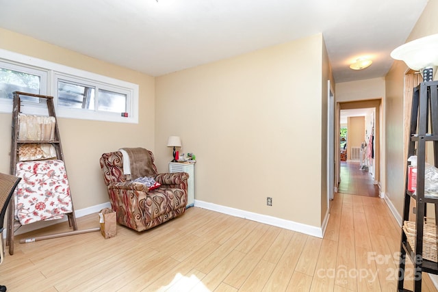 sitting room featuring plenty of natural light, light wood-style flooring, and baseboards