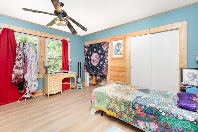 bedroom featuring two closets, ceiling fan, and wood finished floors
