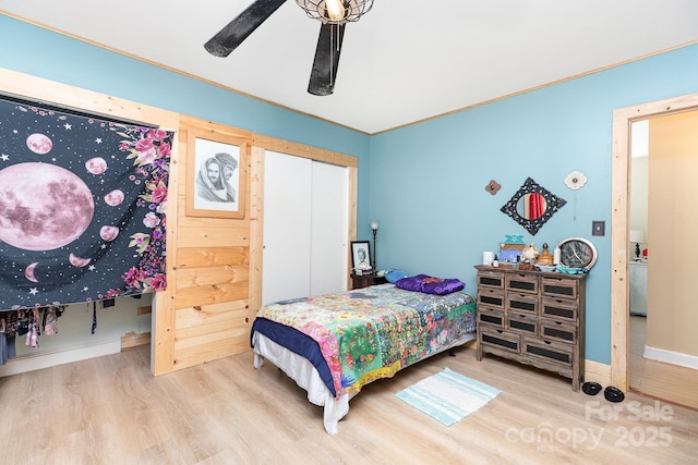 bedroom featuring wood finished floors, a closet, a ceiling fan, and baseboards