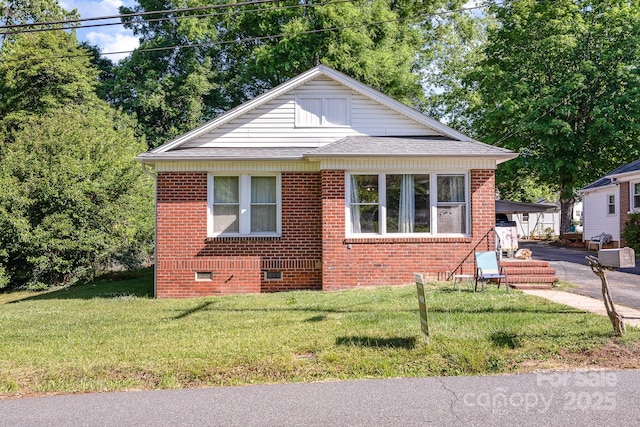 bungalow-style home with brick siding, crawl space, roof with shingles, and a front yard