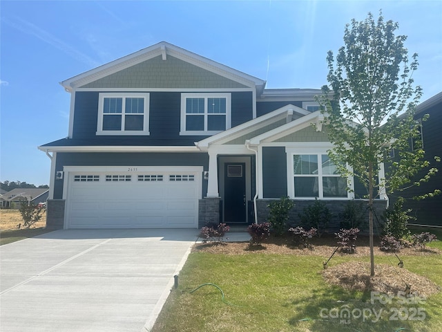 craftsman inspired home featuring concrete driveway, a front lawn, stone siding, and a garage