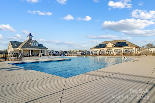 community pool featuring a patio and fence