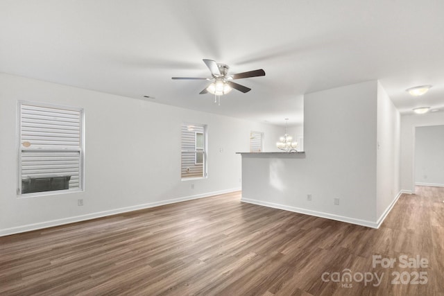 7616 Monarch Birch Ln, Charlotte, NC 28215 - unfurnished living room with baseboards, ceiling fan with notable chandelier, wood finished floors, and visible vents