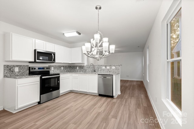 7616 Monarch Birch Ln, Charlotte, NC 28215 - kitchen featuring stainless steel appliances, a notable chandelier, a sink, and light wood-type flooring