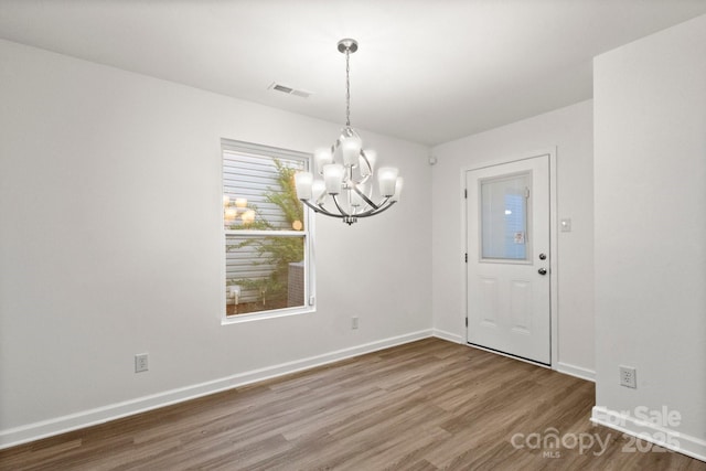 7616 Monarch Birch Ln, Charlotte, NC 28215 - unfurnished dining area with baseboards, visible vents, an inviting chandelier, and wood finished floors