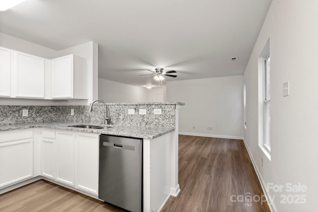 7616 Monarch Birch Ln, Charlotte, NC 28215 - kitchen featuring a sink, light wood-style floors, dishwasher, a peninsula, and white cabinetry