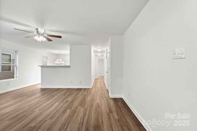 7616 Monarch Birch Ln, Charlotte, NC 28215 - unfurnished living room with baseboards, dark wood finished floors, and ceiling fan with notable chandelier
