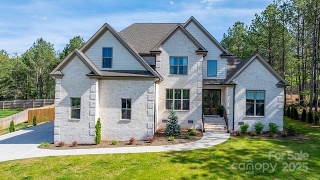 view of front of property featuring french doors, brick siding, and a shingled roof