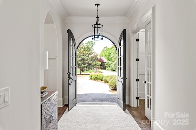 entryway with baseboards, dark wood-style flooring, ornamental molding, and french doors