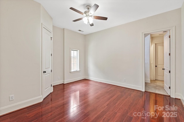 unfurnished bedroom featuring baseboards, ceiling fan, visible vents, and wood finished floors