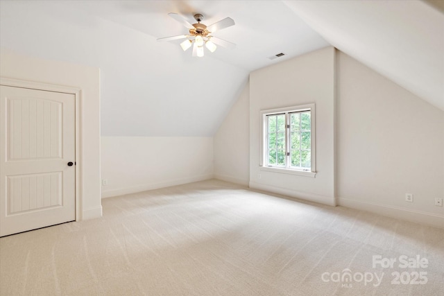additional living space with vaulted ceiling, carpet flooring, baseboards, and visible vents