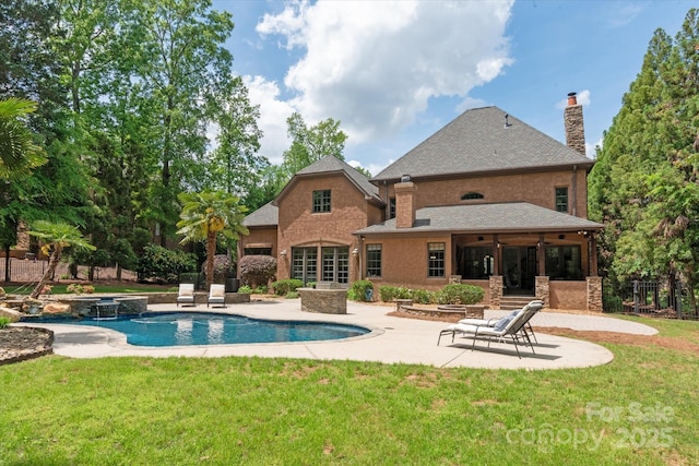view of swimming pool featuring a yard, a patio area, a pool with connected hot tub, and fence