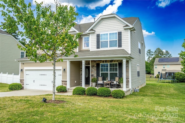 217 Hydrangea Dr, Clover, SC 29710 - view of front of property with a front lawn, stone siding, concrete driveway, a porch, and a trampoline