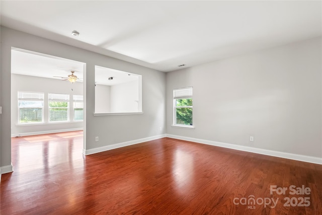spare room with baseboards, a ceiling fan, and wood finished floors