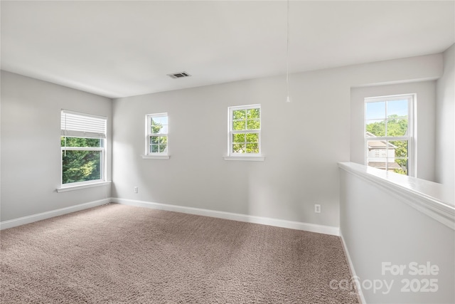 carpeted empty room with baseboards and visible vents