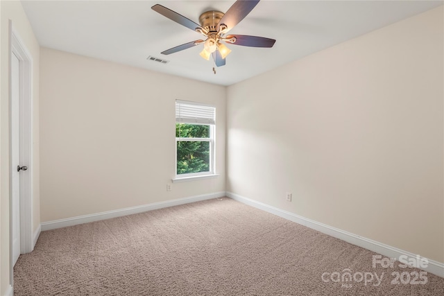 carpeted spare room featuring visible vents, a ceiling fan, and baseboards