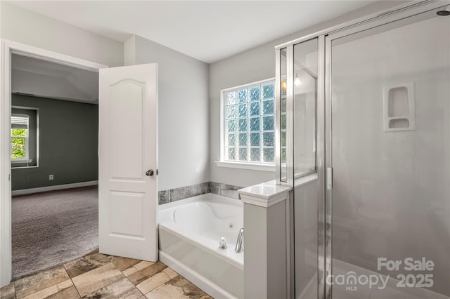 full bathroom featuring plenty of natural light, a shower stall, and a bath