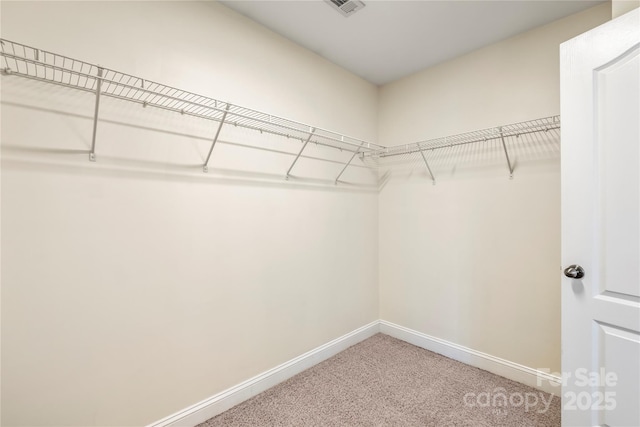 walk in closet featuring light colored carpet and visible vents