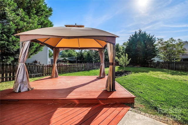 wooden terrace featuring a yard, a gazebo, and a fenced backyard