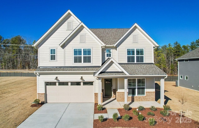 2008 Waxhaw Crossing Dr, Waxhaw, NC 28173 - view of front of home featuring covered porch, roof with shingles, brick siding, concrete driveway, and an attached garage