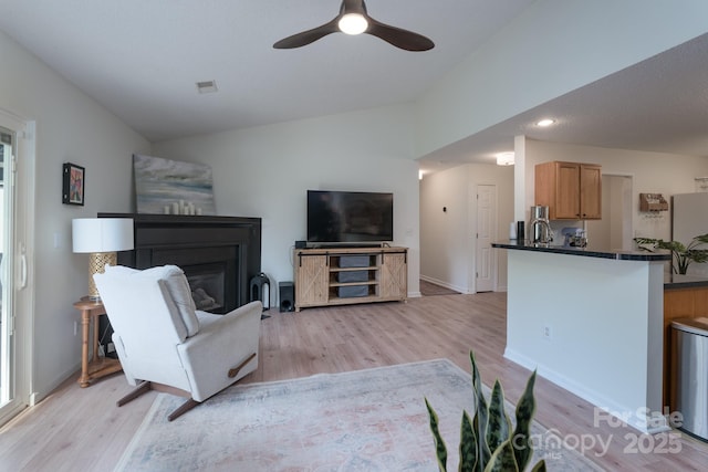 744 Chipmeadow Ln, York, SC 29745 - living area with vaulted ceiling, light wood finished floors, a ceiling fan, baseboards, and a glass covered fireplace