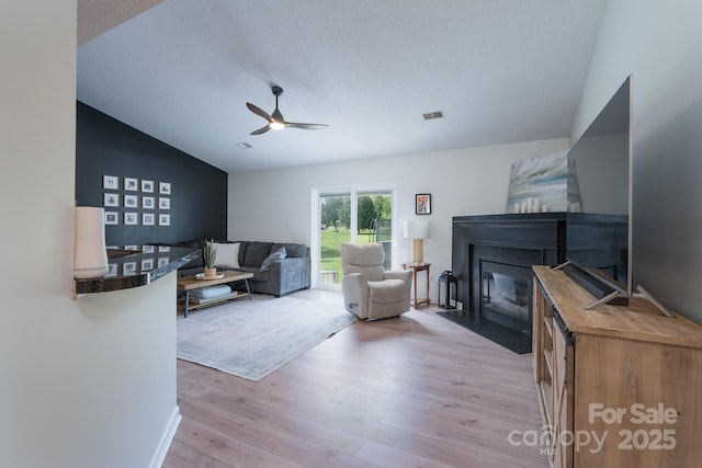 744 Chipmeadow Ln, York, SC 29745 - living area featuring a fireplace with flush hearth, a ceiling fan, light wood-style floors, and lofted ceiling