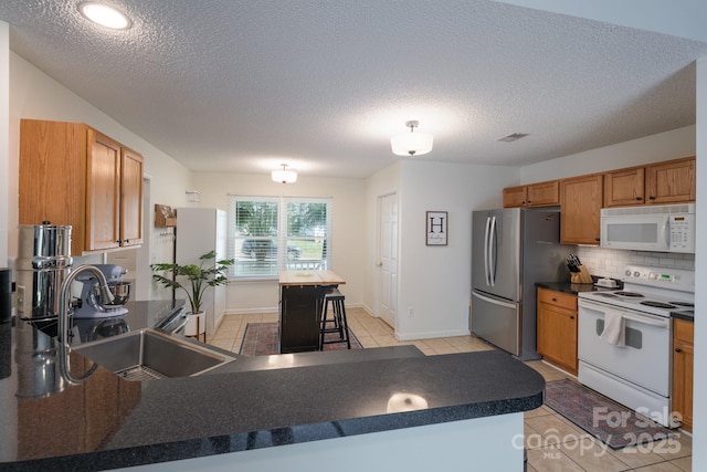 744 Chipmeadow Ln, York, SC 29745 - kitchen featuring white appliances, a sink, dark countertops, backsplash, and light tile patterned flooring