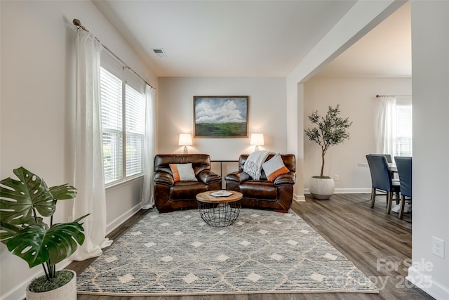 sitting room with baseboards, wood finished floors, and visible vents