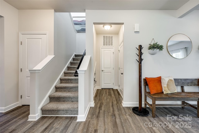 stairs featuring baseboards, visible vents, and wood finished floors