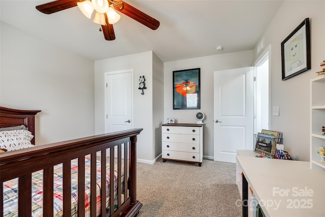 bedroom featuring light colored carpet, a ceiling fan, and baseboards
