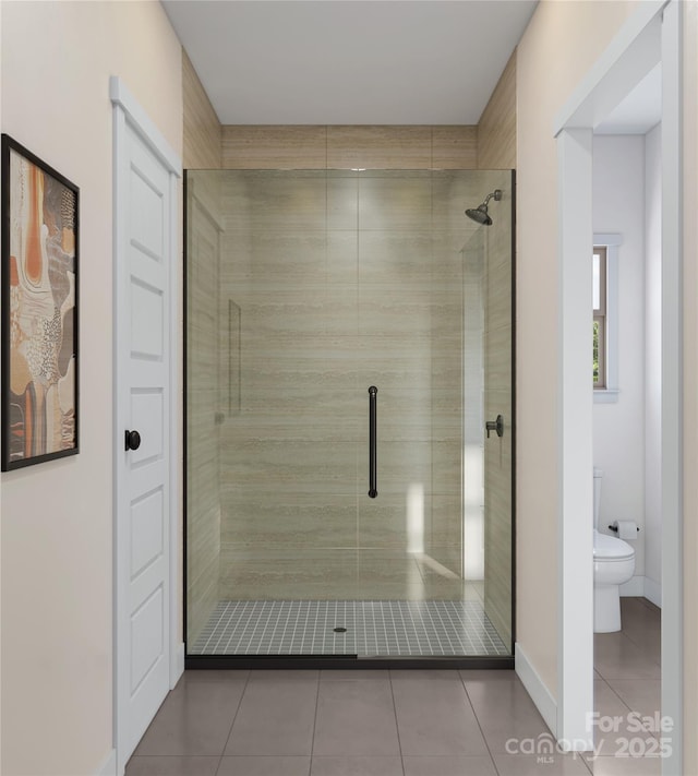 full bath featuring tile patterned flooring, baseboards, a stall shower, and toilet