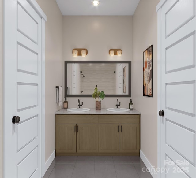 bathroom featuring a sink, baseboards, and tile patterned flooring