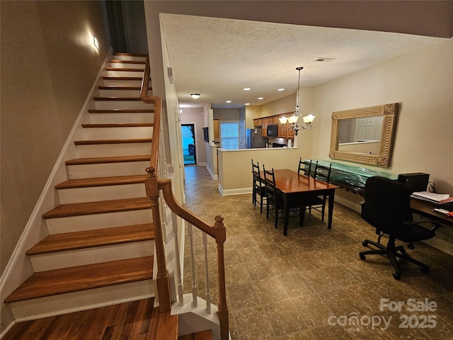 stairs with a textured ceiling, visible vents, tile patterned floors, baseboards, and an inviting chandelier