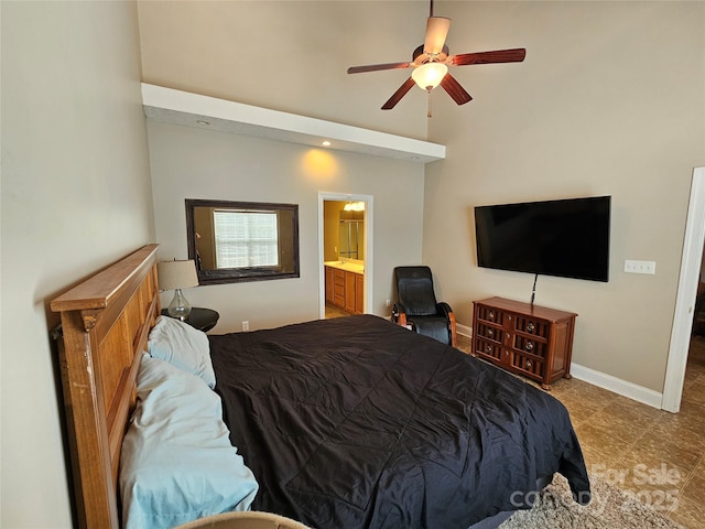 bedroom featuring ensuite bathroom, a ceiling fan, tile patterned flooring, baseboards, and a high ceiling