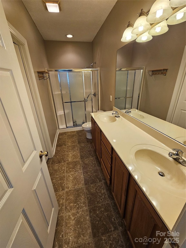full bathroom with a sink, a shower stall, and toilet
