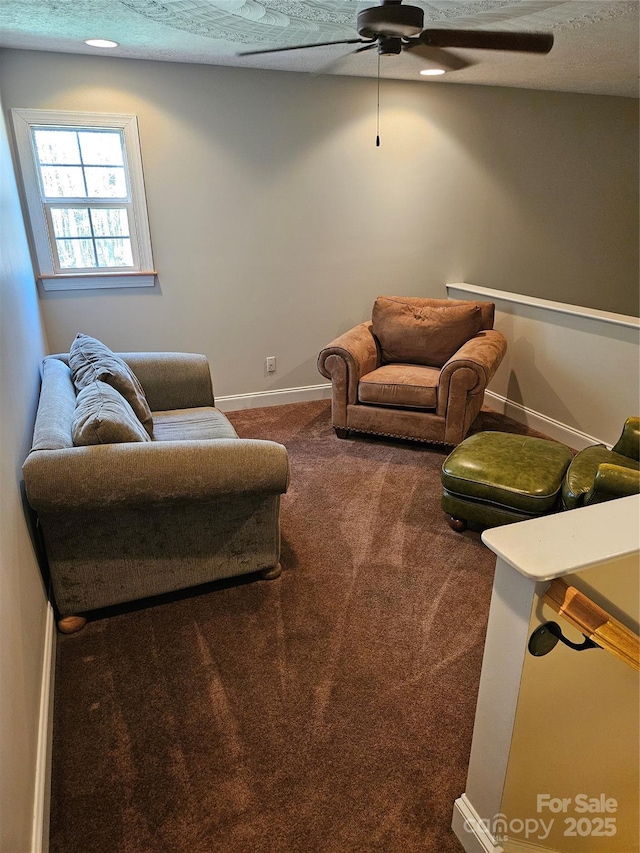 carpeted living area featuring a ceiling fan and baseboards