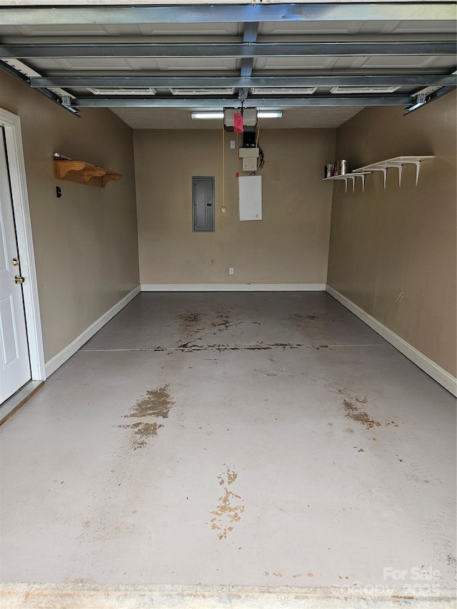 garage with baseboards and electric panel