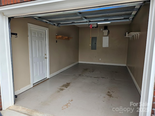 garage with baseboards and electric panel