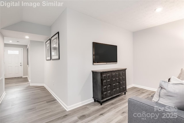 living room featuring recessed lighting, baseboards, and light wood-type flooring