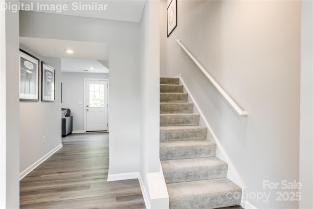 staircase with recessed lighting, baseboards, and wood finished floors