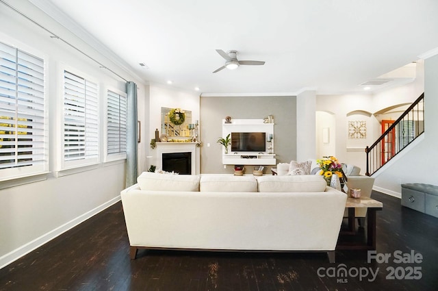 living area with a ceiling fan, stairway, baseboards, dark wood-type flooring, and arched walkways