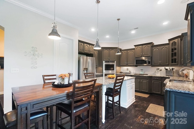 kitchen featuring light stone countertops, a center island, glass insert cabinets, a sink, and stainless steel appliances