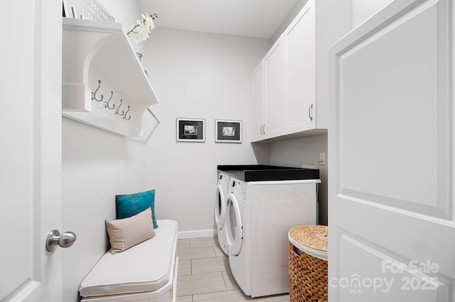 laundry room with washing machine and clothes dryer, baseboards, light tile patterned floors, and cabinet space