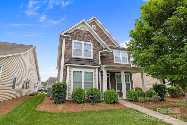 1004 Craven St, Indian Trail, NC 28079 - craftsman-style home featuring stone siding, a front yard, a standing seam roof, and a porch