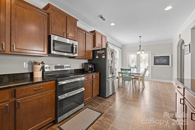 1004 Craven St, Indian Trail, NC 28079 - kitchen featuring stainless steel appliances, crown molding, brown cabinetry, decorative light fixtures, and dark stone countertops
