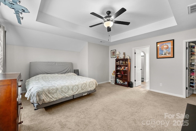 1004 Craven St, Indian Trail, NC 28079 - carpeted bedroom featuring a tray ceiling, baseboards, a walk in closet, a ceiling fan, and a closet